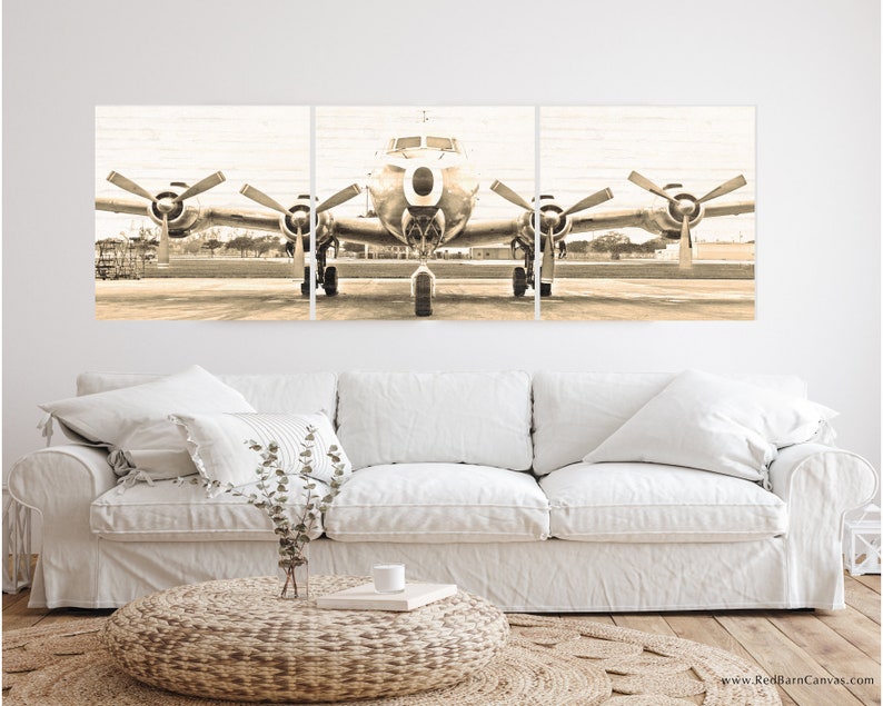 Puede incluir: Una impresi&oacute;n en lienzo vintage de tres paneles de un avi&oacute;n plateado en una pista. El avi&oacute;n tiene dos h&eacute;lices en cada ala y est&aacute; mirando hacia la c&aacute;mara. La imagen est&aacute; en tonos sepia.