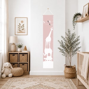 May include: A vertical wall-hanging growth chart in dusty pink featuring a white silhouette of a giraffe standing on an elephant, which is standing on a turtle. The design includes small birds on a wire and printed measurement markings in inches.