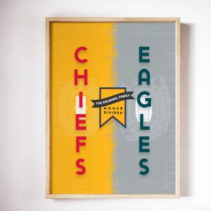 May include: Framed art print with a split design featuring the words "CHIEFS" in red and "EAGLES" in teal. The background is divided into yellow and gray sections, with stadium schematics and the text "THE KRUMMEL FAMILY HOUSE DIVIDED".
