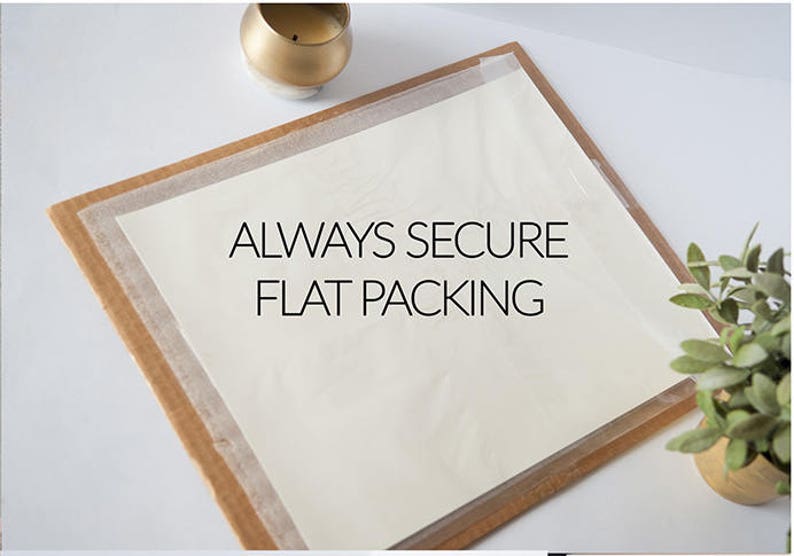 May include: A close-up of a white sheet of paper with the text "ALWAYS SECURE FLAT PACKING" printed in black on a wooden surface.