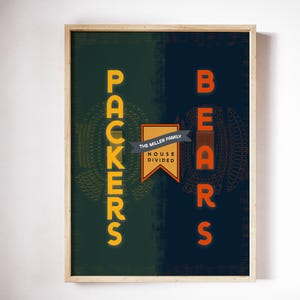 May include: Framed art print with a split design featuring the words "PACKERS" in yellow on a green background and "BEARS" in orange on a navy background. The text "THE MILLER FAMILY HOUSE DIVIDED" is in a banner in the center.
