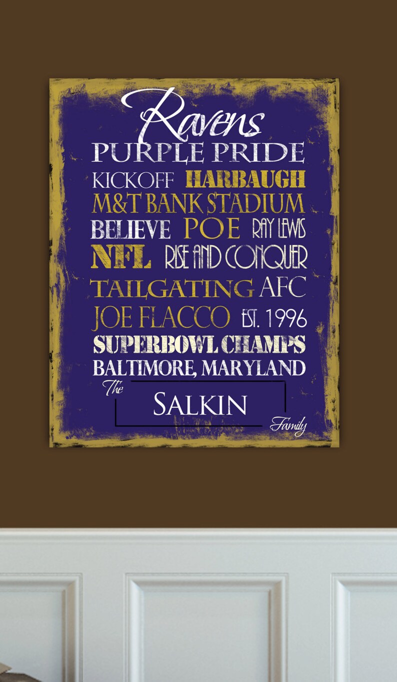 Może przedstawiać: Fioletowo-złoty znak z napisem "Ravens Purple Pride" i innymi szczeg&oacute;łami dotyczącymi drużyny, w tym "Baltimore, Maryland" i "The Salkin Family".