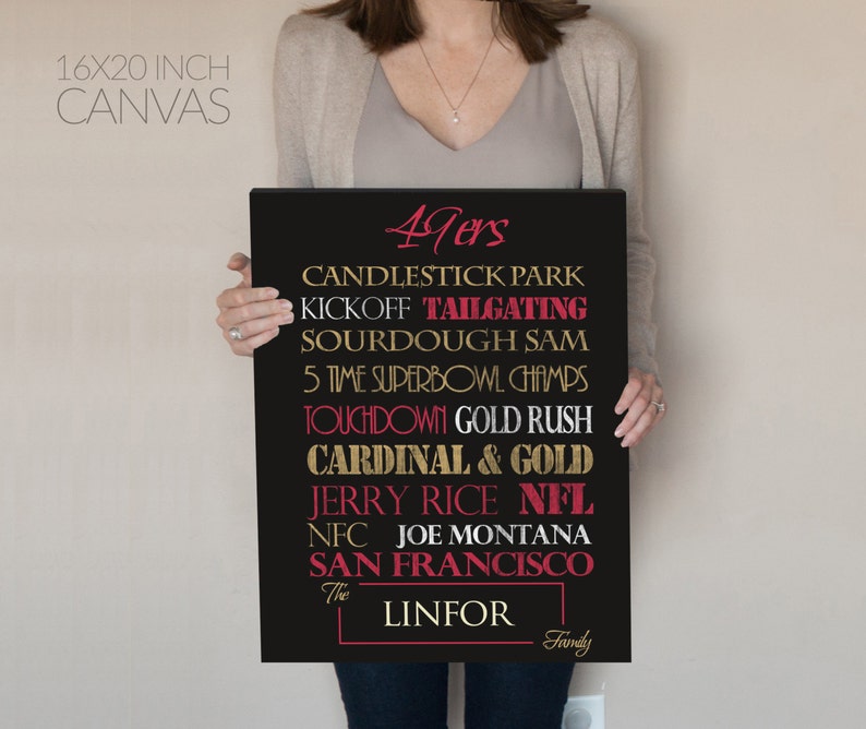 May include: A black canvas print with gold and red text. The text reads "49ers", "Candlestick Park", "Kickoff Tailgating", "Sourdough Sam", "5 Time Superbowl Champs", "Touchdown Gold Rush", "Cardinal & Gold", "Jerry Rice NFL", "NFC Joe Montana", "San Francisco", "The Linfor Family".