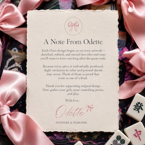 May include: A cream-colored note card with deckled edges featuring the text A Note From Odette, a pink bow icon, and a signature. The card is surrounded by pink satin ribbons and white mahjong tiles with black and red characters on a dark background.