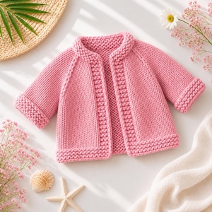 May include: A long-sleeved, open-front cardigan sweater in a solid light pink color. The garment features a chunky knit texture with a distinct garter stitch border along the neckline, front opening, cuffs, and bottom hem, creating a structured look.