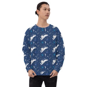 Könnte beinhalten: Ein marineblauer Pullover mit einem weißen Löwen- und Blumenmuster. Der Löwe trägt eine Krone und hat einen verspielten Ausdruck.