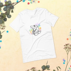 Könnte beinhalten: Weißes T-Shirt mit einer schwarzen Linienzeichnung eines Comic-Alligators, der eine Blume hält. Der Alligator ist von bunten Blumen umgeben.