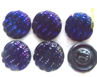 May include: Six iridescent black glass buttons with a raised swirl design. The buttons are approximately 1 inch in diameter.
