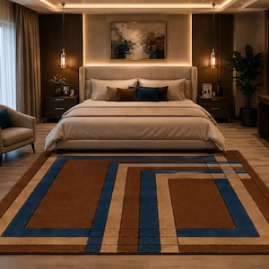 May include: A rectangular area rug featuring a geometric pattern with bold blue, tan, and dark brown stripes. The design consists of nested rectangular frames and linear accents that create a structured, layered appearance across the floor surface.