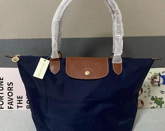 Sac cabas Longchamp Le Pliage bleu marine grand format, en nylon avec finitions en cuir, pliable et léger, idéal pour un usage quotidien.