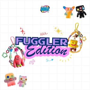 May include: A collection of Fuggler-themed keychains and small figurines. The keychains feature colourful beads, charms, and miniature character figures. The text FUGGLER Edition is displayed in the centre. Several small, colourful, button-eyed monster figurines are arranged around the text.