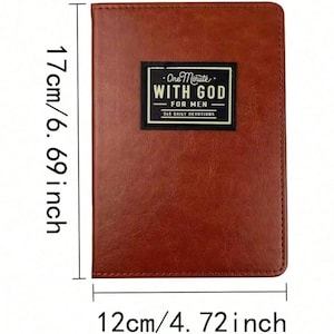 Puede incluir: Un libro de devociones rectangular de color marr&oacute;n con una cubierta texturizada. Una etiqueta negra en la parte frontal presenta el texto blanco "One Minute WITH GOD FOR MEN 365 DAILY DEVOTIONS". El libro mide 17 cm por 12 cm, o 6,69 pulgadas por 4,72 pulgadas.
