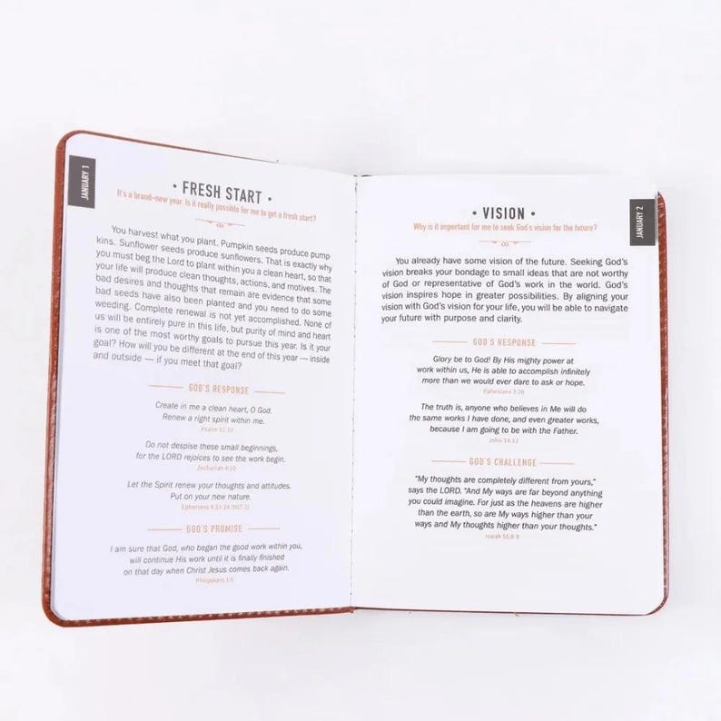 Puede incluir: Un libro devocional abierto con p&aacute;ginas blancas y texto negro. La p&aacute;gina izquierda se titula Fresh Start para el 1 de enero y la derecha se titula Vision para el 2 de enero. Ambas p&aacute;ginas contienen p&aacute;rrafos de texto, citas y encabezados.