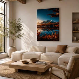 Könnte beinhalten: Ein rechteckiger Wandkunstdruck mit einer Landschaft aus schneebedeckten Bergen, die sich bei Sonnenuntergang in einem ruhigen See spiegeln. Das Bild zeigt einen dunkelblauen Himmel, orangefarbenes Laub im Vordergrund und einen dichten Wald.