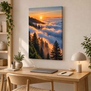 May include: A rectangular canvas wall art print featuring a landscape of evergreen trees on a mountainside overlooking a sea of clouds at sunset. The sky is filled with warm orange and yellow light, casting a golden glow over the dense forest.