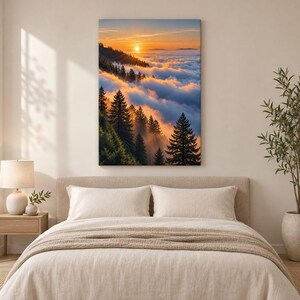 May include: A vertical rectangular wall art print featuring a sunrise over a dense forest of evergreen trees partially obscured by a thick layer of clouds. The sky displays warm orange and yellow hues, casting a golden glow on the misty landscape.