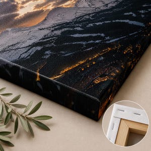 May include: A rectangular canvas print featuring a dark mountain landscape at night with glowing golden city lights and a sunset sky. The canvas is stretched over a wooden frame, shown in a circular inset detail revealing the back corner construction.