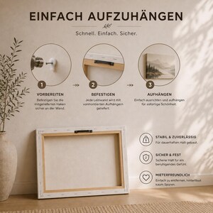 K&ouml;nnte beinhalten: Eine Anleitungsgrafik mit dem Titel EINFACH AUFZUH&Auml;NGEN zeigt drei Schritte zum Aufh&auml;ngen einer Leinwand: 1. Haken an der Wand befestigen, 2. Vormontierte Halterung am Rahmen nutzen, 3. Leinwand aufh&auml;ngen. Ein leerer Leinwandrahmen ist abgebildet.