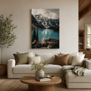Könnte beinhalten: Ein vertikaler Wandkunstdruck mit einer Landschaft aus einem türkisfarbenen Gletschersee, umgeben von dunklen, zerklüfteten, schneebedeckten Bergen unter einem bewölkten Himmel. Der Vordergrund zeigt felsiges Gelände und Nadelbäume.