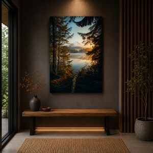 May include: A rectangular wall art print featuring a landscape of a calm lake surrounded by dark pine trees, with a snow-capped mountain in the distance under a golden sunrise sky, displayed above a long wooden bench in a room.