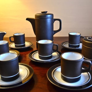 May include: A black and white coffee set with a teapot, creamer, sugar bowl, and six cups and saucers.