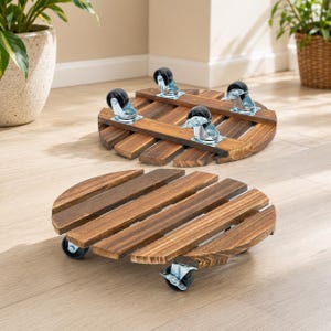 May include: Two round plant caddies constructed from dark brown stained wooden slats. Each caddy features four black swivel casters with silver metal hardware attached to the underside, allowing for mobility across flat surfaces.