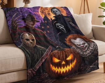 May include: A rectangular throw blanket featuring a dark purple and orange horror-themed print. The design displays four iconic movie villains, a glowing jack-o'-lantern, and a haunted house silhouette against a full moon background.