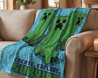 May include: A soft blue fleece throw blanket featuring a repeating pattern of green Minecraft Creeper characters. The blanket displays the text "CREATE, EXPLORE, SURVIVE" in a bold, pixelated font at the bottom, set against a light blue grid background.