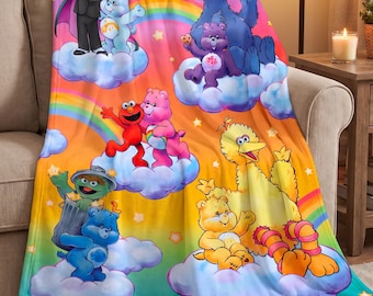 May include: A plush throw blanket featuring a colourful graphic print of Sesame Street characters and Care Bears sitting on clouds. The design includes Elmo, Cookie Monster, Big Bird, Count von Count, and Oscar the Grouch alongside various Care Bears, all set against a vibrant rainbow and star-filled background.
