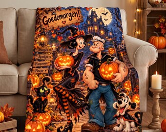 May include: A fleece throw blanket featuring a Halloween scene with Olive Oyl as a witch and Popeye holding pumpkins. The design includes a black cat, a dog, a haunted house, and wooden signs with the text Goedemorgen, Shoepjes, Spookjes, Pompoenen, and Plezier.