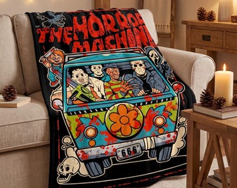 May include: A black throw blanket featuring a colourful graphic of a van with horror movie characters, including a masked figure, a clawed character, and a doll. The text reads THE HORROR MACHINE and the license plate displays 666.