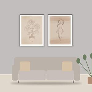 minimalist one-line art printable art framed above a sofa in a styled living room