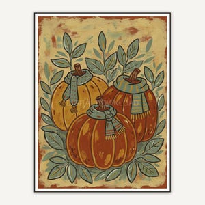 Three small pumpkins with scarves among sage leaves