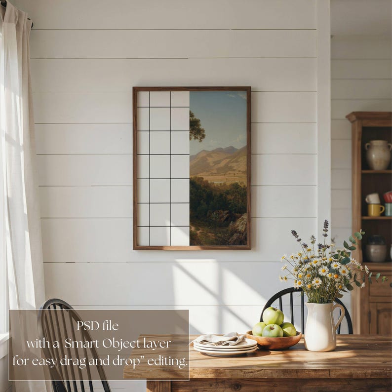 May include: A rectangular wooden frame hanging on a white horizontal paneled wall. The frame contains a split image featuring a white grid pattern on the left side and a landscape painting of mountains, trees, and a blue sky on the right side.