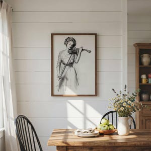 May include: A framed black and white line art print depicting a person playing a violin, mounted on a white horizontal plank wall. The artwork features a detailed sketch of a figure in a dress holding a violin and bow, captured in a classic style.