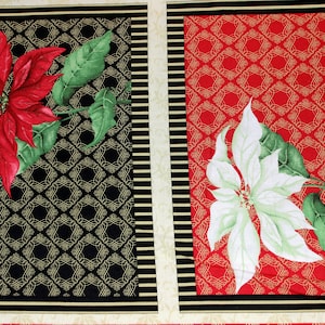 Op de afbeelding: Twee rode en witte kerststerren op een stof met een geometrisch patroon in zwart en goud en een geometrisch patroon in rood en goud.