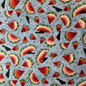 May include: A blue fabric with a repeating pattern of watermelon slices and black birds. The watermelon slices are red with green rinds and black seeds. The birds are simple silhouettes.