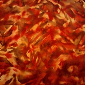 Op de afbeelding: Een stof met een abstract patroon in gemengde tinten diep rood, gebrand oranje en donkerbruin. Het ontwerp vertoont een aquarelachtig effect met overlappende organische vormen en zachte, diffuse randen over het gehele oppervlak.