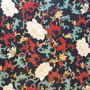 Puede incluir: Una tela negra con un patrón repetitivo de flores blancas y enredaderas doradas y rojas. Las flores tienen un centro dorado y las enredaderas tienen un esquema de color rojo y dorado.