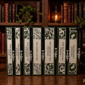 Puede incluir: Un conjunto de siete libros con lomos verdes y crema, cada uno con un marcapáginas de cinta negra con un dije de serpiente plateado. Los títulos incluyen The Sorcerer's Stone, The Chamber of Secrets, The Prisoner of Azkaban, The Goblet of Fire, The Order of the Phoenix, The Half-Blood Prince y The Deathly Hallows.