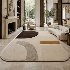 May include: A large area rug featuring a cream-colored base with geometric shapes in dark brown, light gray, and mustard yellow. The rug has rounded corners and a textured surface with a mix of solid blocks and curved, ribbed line patterns.
