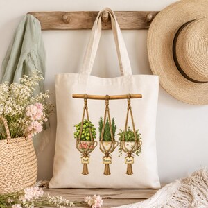 May include: A cream-colored canvas tote bag featuring a printed illustration of three macrame plant hangers suspended from a wooden rod. Each hanger holds a teacup containing a green herb labeled Basil, Rosemary, or Thyme in cursive script.