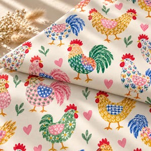 Peut inclure: Un tissu de couleur crème présentant un motif répétitif de coqs et de poules colorés dans des tons de jaune, rose, vert et bleu. Le design comprend de petits cœurs roses et des brins de feuilles vertes dispersés entre les oiseaux sur le textile.