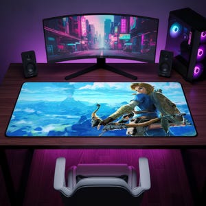 May include: A rectangular desk mat featuring a vibrant, high-definition illustration of a video game character holding a bow and arrow against a sprawling blue landscape with mountains and a volcano under a bright, cloudy sky.