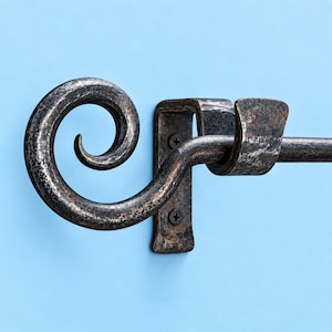 May include: A dark, hammered metal curtain rod bracket featuring a prominent decorative scroll finial. The bracket is secured to the wall with two black screws and includes a curved cradle to hold a horizontal rod in place, showing a textured finish.