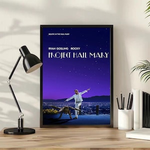 Op de afbeelding: Een rechthoekige filmposter voor Project Hail Mary in een zwarte lijst. De poster toont een donkerblauwe sterrenhemel boven een stadslandschap, met een persoon in een wit pak en een wezen dat op een richel staat. De tekst luidt: BELIEVE IN THE HAIL MARY, RYAN GOSLING, ROCKY, PROJECT HAIL MARY.