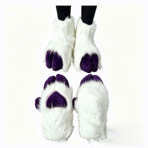 May include: A pair of white faux fur boots and a pair of matching white faux fur mittens. Both items feature deep purple velvet-like fabric accents on the toes and the palm pads, creating a distinct contrast against the long white synthetic fur.