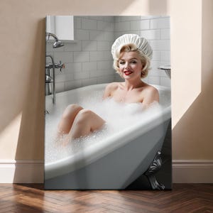 May include: A rectangular wall art print featuring a blonde person with red lipstick wearing a white shower cap, sitting in a white clawfoot bathtub filled with soap bubbles. The background shows white subway tiles and a chrome faucet fixture.