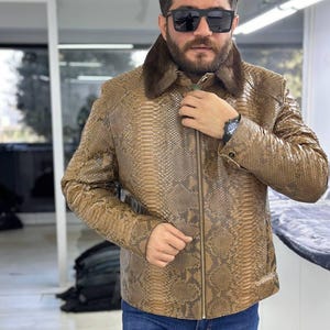 Chaqueta marrón con estampado de pitón, cuello de piel de visón, cierre de cremallera y puños ajustables.
