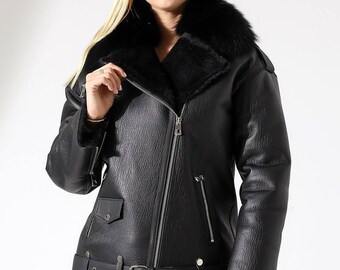 Giacca nera in vera pelle con ampio collo in pelliccia, capospalla invernale da donna in pelle, cappotto moderno con cerniera frontale, elegante strato per le giornate fredde.